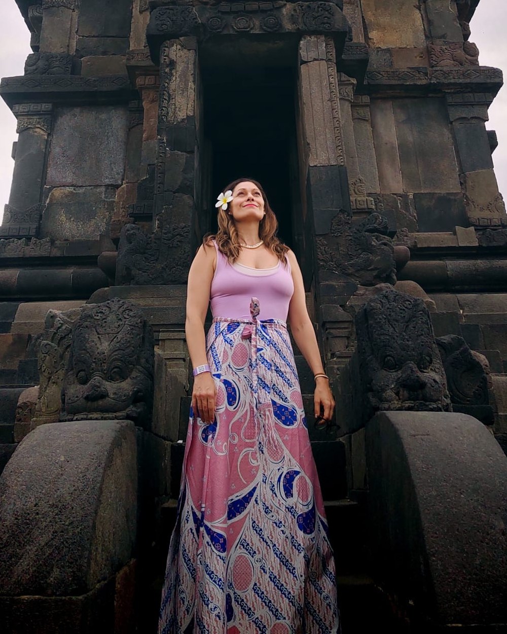 Priscilla Hidalgo standing at the foot of a temple at Prambanan, Java, looking up.
